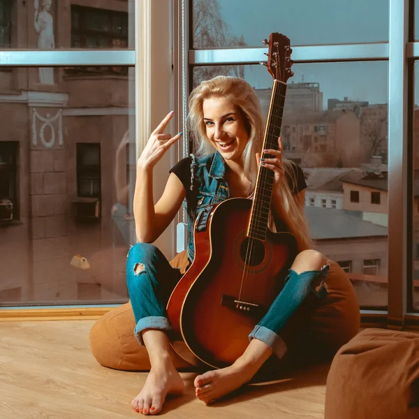 Photo of fun blonde woman with guitar and beautiful smile