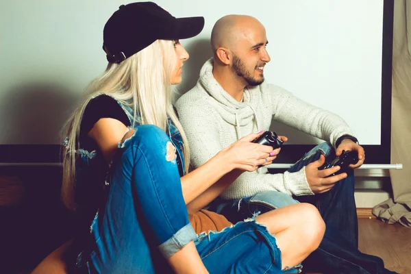 Fashionable couple having fun and playing computer games