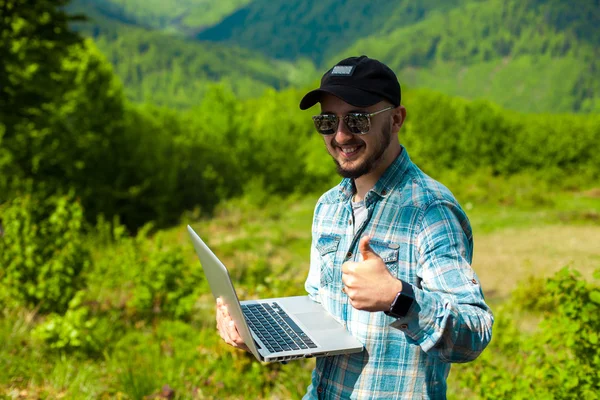 Male model working in the mountains on a laptop