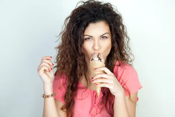 Serious young woman eats ice cream cone