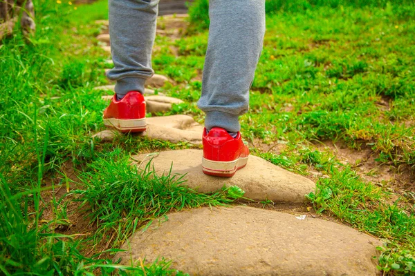 Man in red sneakers on a path
