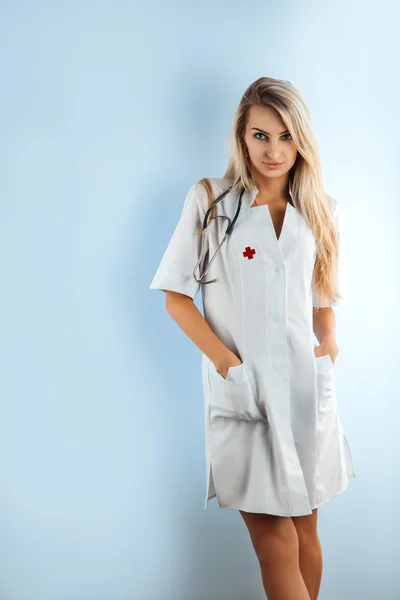Charming blonde nurse in white medical gown