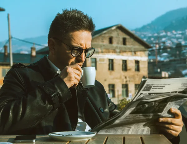 Beautiful adult business man drink coffe and read newspaper