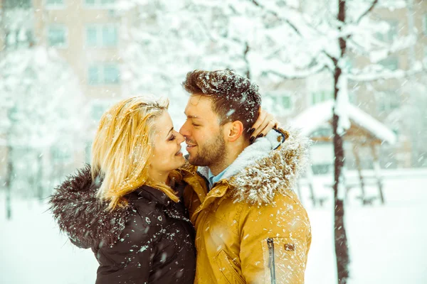 Couple hugging and looking into each other\'s eyes in the snow
