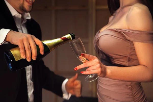 Photo without faces of man and woman with champagne