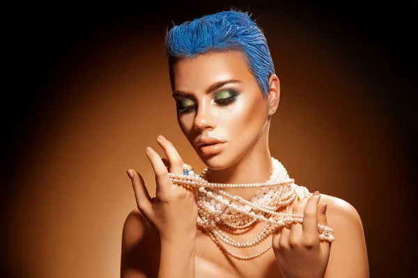 Sensual portrait of young woman with pearls short blue hairstyle