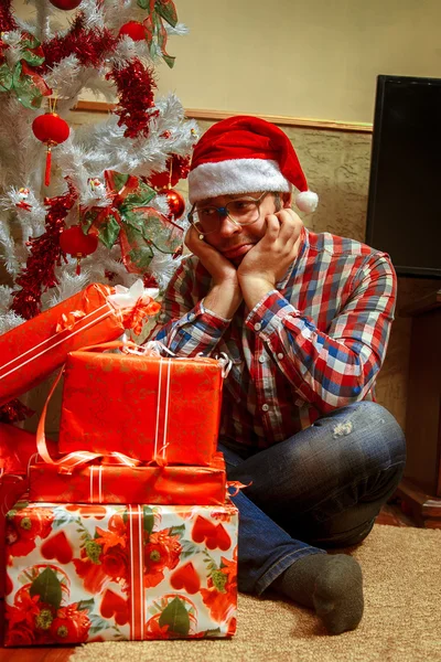 Sad lonely nerd with a bunch of Christmas gifts