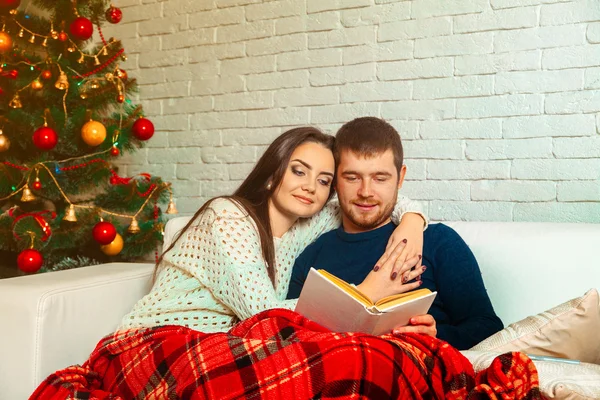 Attractive young couple reads a christmas story