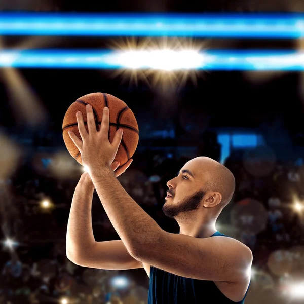 Bald sportsman playing basketball and thorws a ball