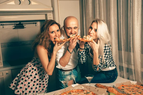 Cheerful group of young people at home pizza party