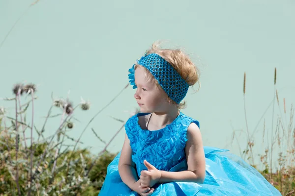 Little child girl on grass on meadow.