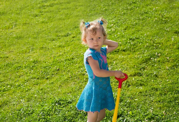 Little child girl on grass on meadow.