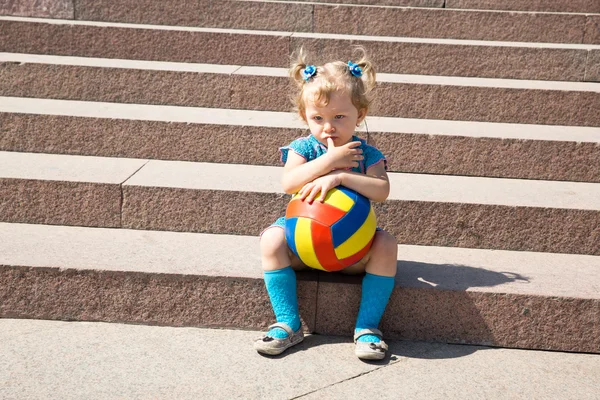 Little child girl with toy ball in park.