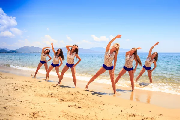 Cheerleaders stand in triangle position