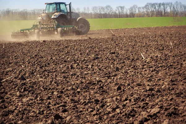Tractor raises dust on soil