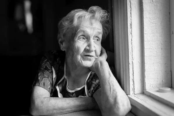 Elderly woman sitting near window