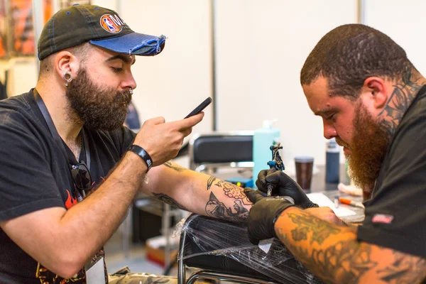 People make tattoos at Tattoo Convention