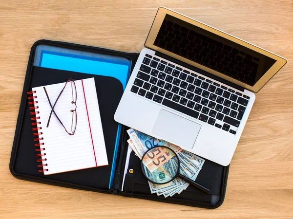 Laptop, glasses and banknotes