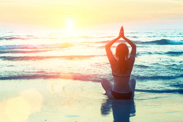 Meditating girl on sea