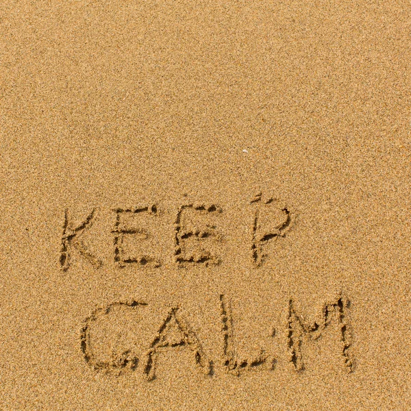 Keep calm - text written on sand