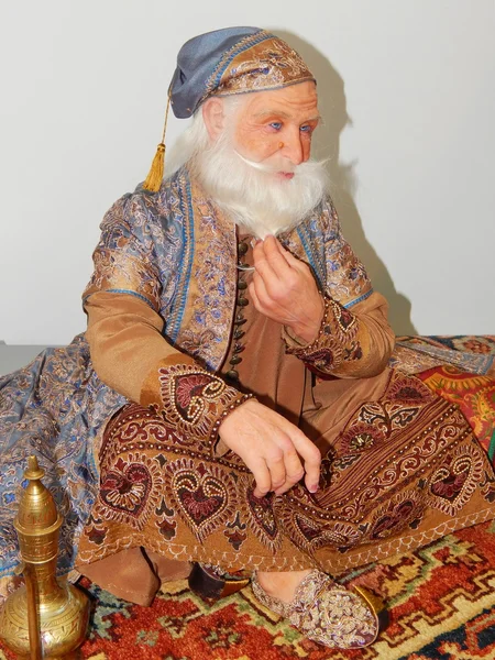 Crafts. A handmade doll - an oriental wise man, sitting on the carpet -  from the International Moscow Exhibition \