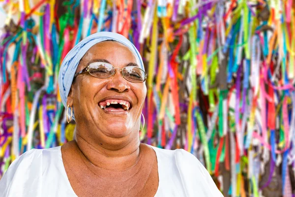 A Brazilian woman of African descent, smiling, wearing traditional clothes in Salvador, Bahia