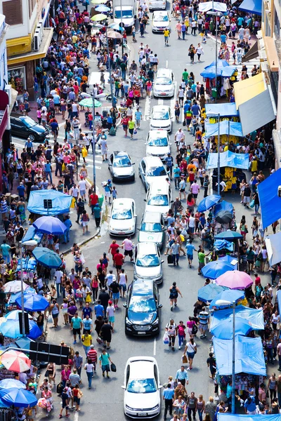 Hundreds of People walk along the 25 March area in Sao Paulo, Brazil. 25 March is a popular commerce region near the center of Sao Paulo, Brazil.