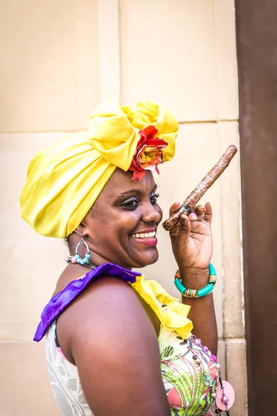 Portrait of african cuban woman smoking cigar and smiling