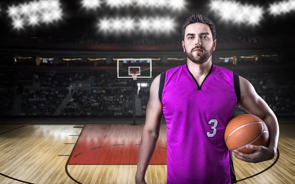 Basketball Player on a purple uniform in basketball court