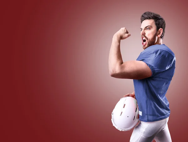 Football Player on blue uniform on red background