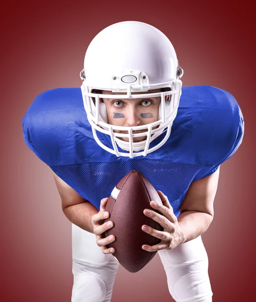 Football Player on blue uniform on red background