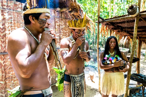 Native Brazilian group playing wooden flute at an indigenous tribe in the Amazon