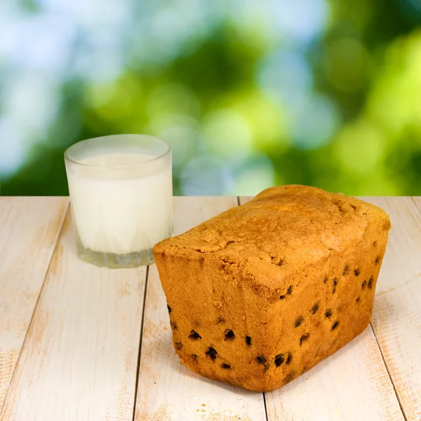 Image of a glass of milk and cake on a green background