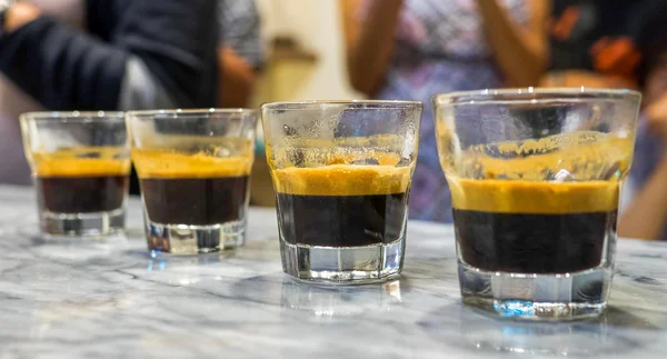 Four glasses of espresso lined up for tasting