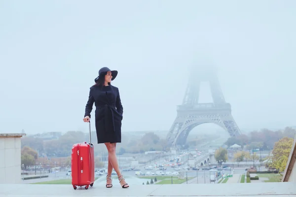 Oman with luggage near Eiffel Tower