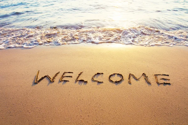 Word welcome  written on sand