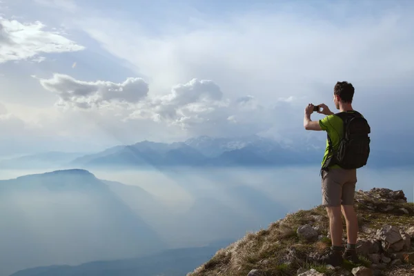 Hiker taking photo of mountain landscape