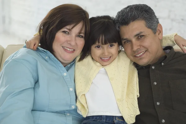 Hispanic parents and daughter hugging