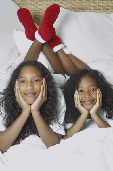 Two African American sisters on bed