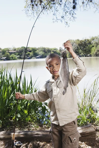 Young African boy with fishing pole and fish