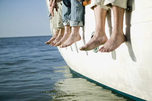 Bare feet hanging over side of boat