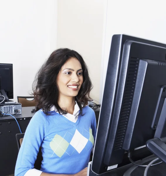 Indian woman using computer and smiling
