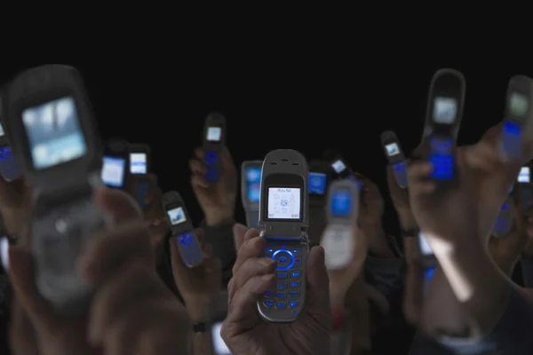 People holding open cell phones up in air