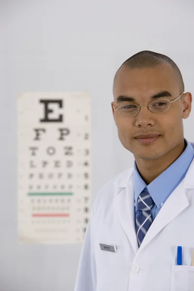 Male doctor in front of eye chart