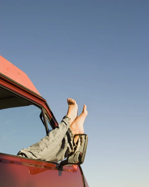 Woman's feet sticking out of car window