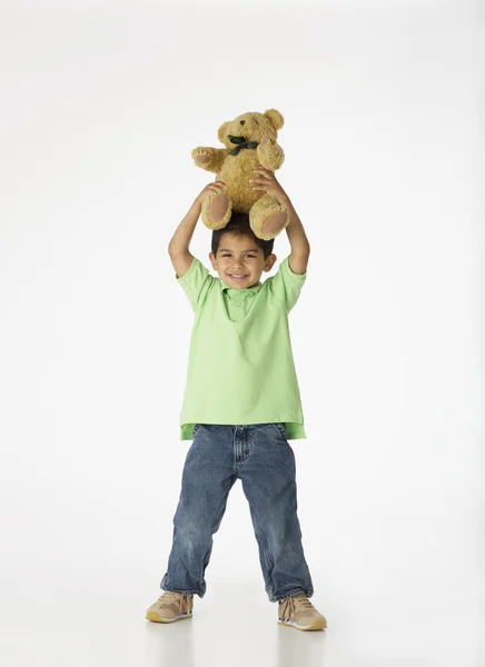 Boy holding teddy bear on top of head