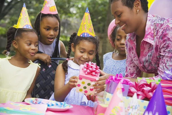 African girl receiving gift at birthday party