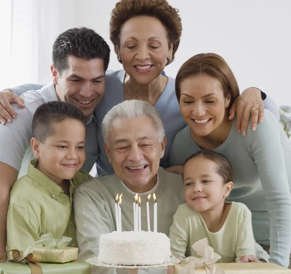 Senior Hispanic man celebrating birthday with family