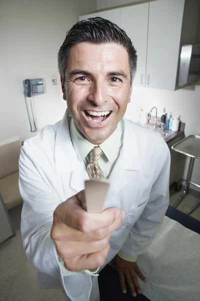 Male doctor with tongue depressor in hand