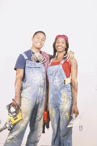 Couple in paint spattered overalls